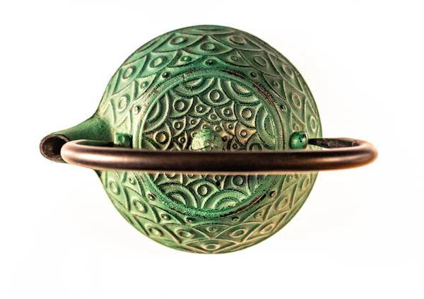 Küflenmiş yeşil dökme demir çaydanlık, geleneksel olarak izole edilmiş.