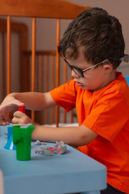 Little baby sculpts plasticine mom with baby.