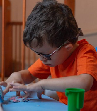 Little baby sculpts plasticine mom with baby close-up