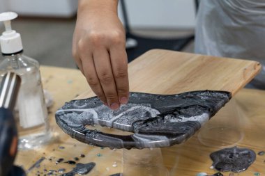 Madalyalı tahtaya gri taşlar serpiyorsun..