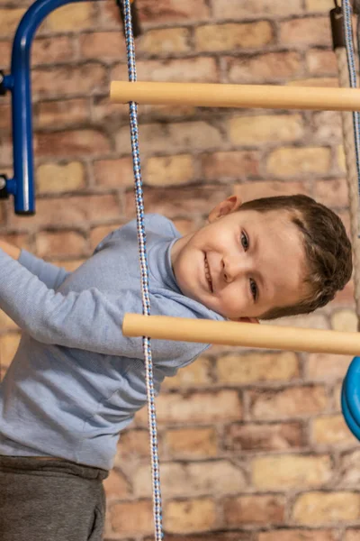 Küçük çocuk evdeki ormancıya tırmanıyor.