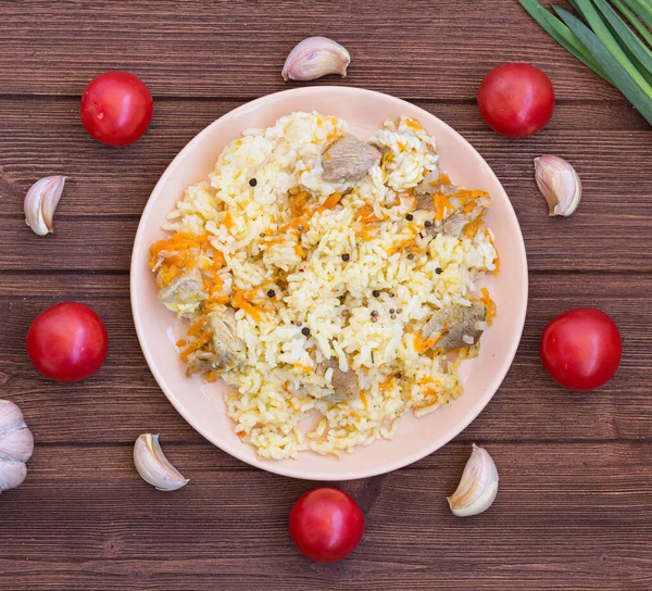 Ahşap bir masada etli ve rujlu pilav..