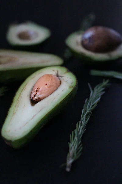 Siyah arkaplanda avokado ve biberiyeyi kes.