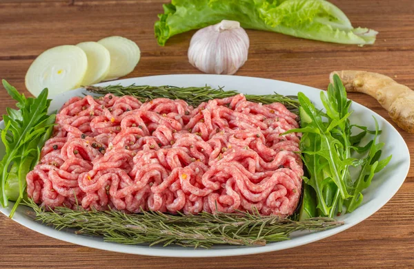 Tahta bir tabakta yeşil et ve baharatlar..