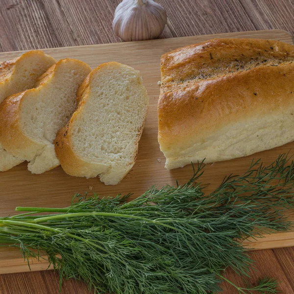 Ekmek, yeşillik ve sarımsak ahşap masa.