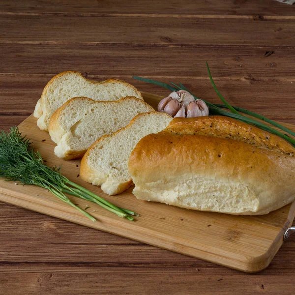 Ekmek, yeşillik ve sarımsak ahşap masa.
