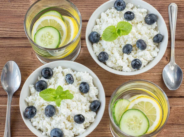 ahşap arka planda iki kişilik yaban mersinli süzme peynir ve Mojito.