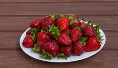 Kırmızı olgun çilekler bir tabak çiftliğinde.