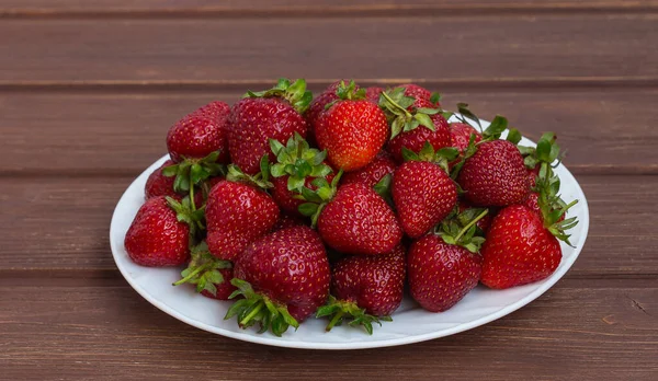 Kırmızı olgun çilekler bir tabak çiftliğinde.