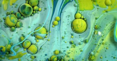 Mavi boya içinde kıvrılan sarı kabarcıklar