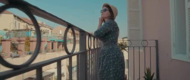 Молодая женщина, стоящая на балконе — стоковое видео