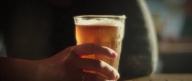 Elinde bira olan bir kadın.