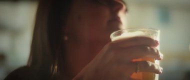 Elinde soğuk bir bardak bira tutan kadın.