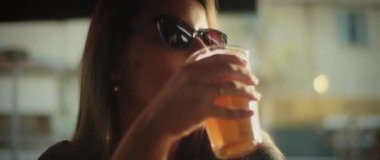 Gün batımında soğuk bira içen bir kadın