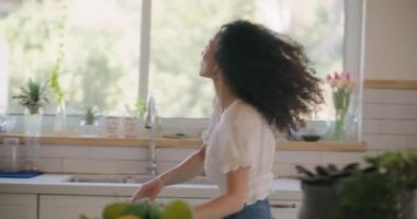 Mutfakta özgürce dans eden bir kız.