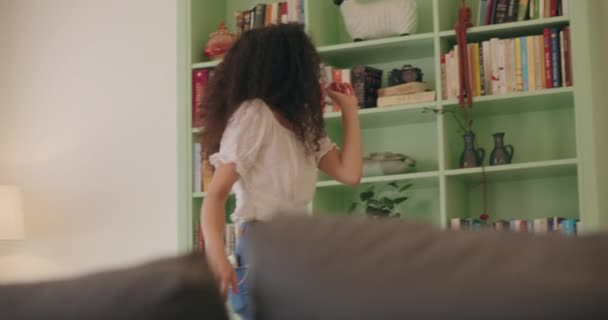 Frau tanzt neben dem Bücherregal — Stockvideo