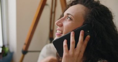 Evde telefonla konuşan bir kadın.