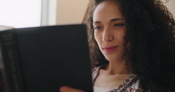 Schöne lächelnde Frau liest ein Buch — Stockvideo