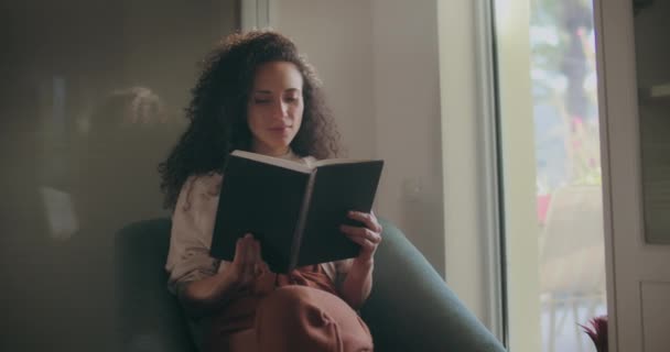 Gemengd ras vrouw lezen door het raam — Stockvideo