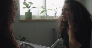 Çaresiz bir kadın yüzüne dokunuyor.