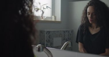 Aynanın karşısında kendine güveni olmayan bir kadın