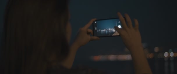 Femme zoome pour prendre une photo d'une ville — Video