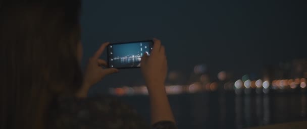 Femme prenant une vidéo d'une ville de nuit — Video