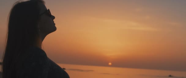 Una mujer disfrutando del hermoso atardecer — Vídeos de Stock