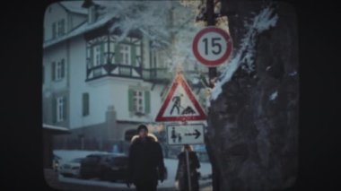 İnsanlar küçük dağlık bir kasabada yürüyor.