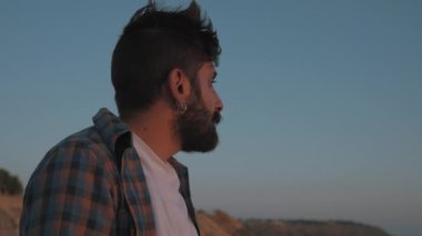 Orta Doğulu adam gün batımına bakıyor.