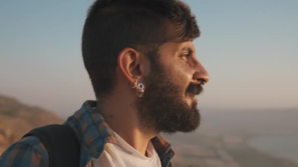 A young bearded man walking at sunset — Vídeos de Stock