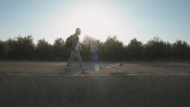 A man with backpack walking with his dog — Vídeos de Stock