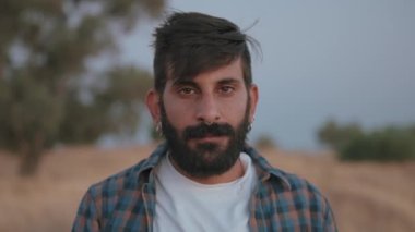 Ciddi bir adam kameraya bakıyor.