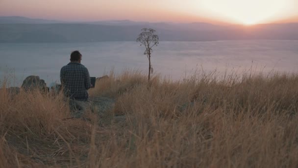 Digital nomad working next to a lake — Stock Video