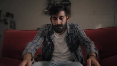 Adam evde dizüstü bilgisayar açıyor.