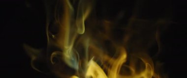 Altın tütsü alevleri siyah arkaplanda kıvranıyor