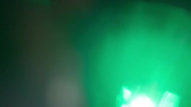 Yeşil ışık sızıntısı ve gökkuşağı prizması ağır çekimde üst üste biner..