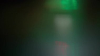 Yeşil ve kırmızı renkli cam prizma yansımasından oluşan soyut ışık sızıntıları sürüsü. Yavaş çekim. 