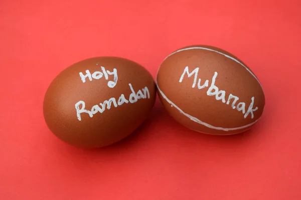 Holy Ramadan Mubarak hand typography on the egg. Red isolated background
