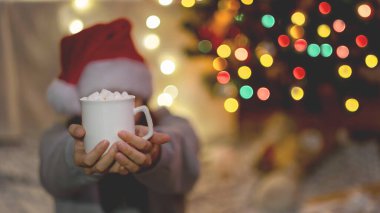 Genç suratsız kadın herkese bir bardak kakao sunar.