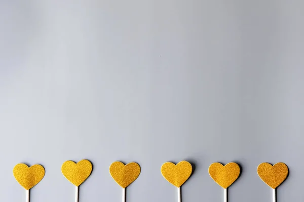 gold hearts on gray paper background. happy valentine's day, minimalism concep