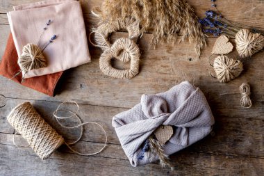 Sıfır Sevgililer Günü konseptini boşa harcamak ve taklit etmek. Furoshiki paketi için tekstil, ve hediye paketleri lavanta, pampa otu ve jüt kalp ile furoshiki stili. Üst görünüm veya düz uzanma.