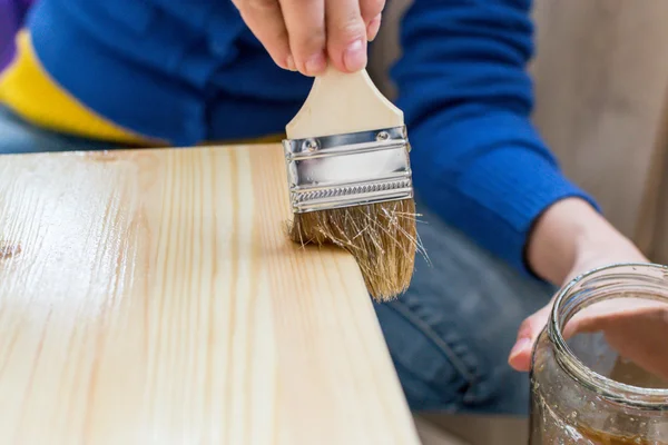 Mujer Paiting Barniz en un taburete de madera — Foto de Stock