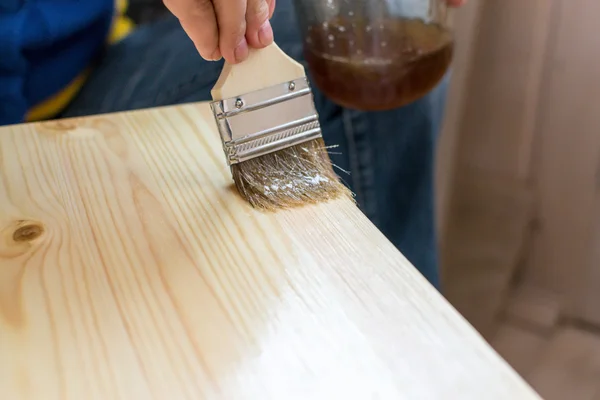 Mujer Paiting Barniz en un taburete de madera — Foto de Stock