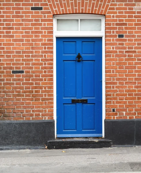 Puerta pintada azul de la casa y ladrillo —  Fotos de Stock