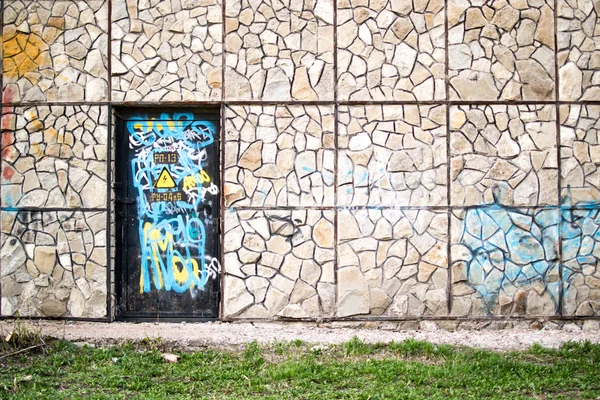 Puerta vandalizada y muro de piedra —  Fotos de Stock