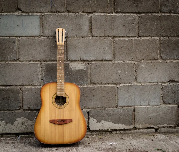 Alte verlassene Gitarre und Backsteinmauer — Stockfoto