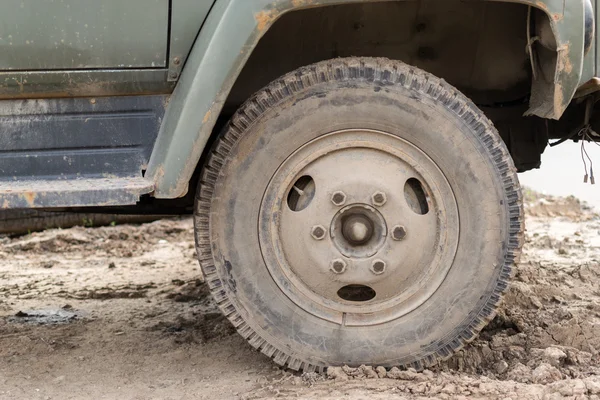 Muddy stof overdekte voertuig wiel — Stockfoto