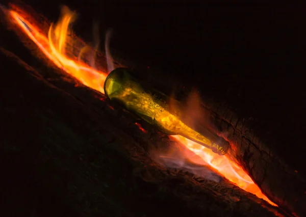 Garrafa de vidro verde e fogueira — Fotografia de Stock