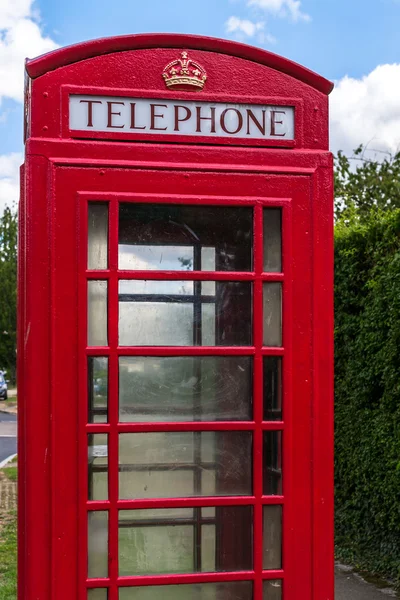Красный телефон с голубым небом — стоковое фото
